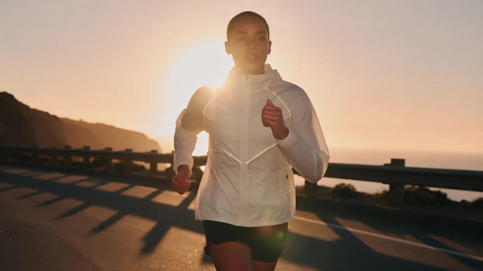 Original campaign scene: a runner on a coastal road at golden hour