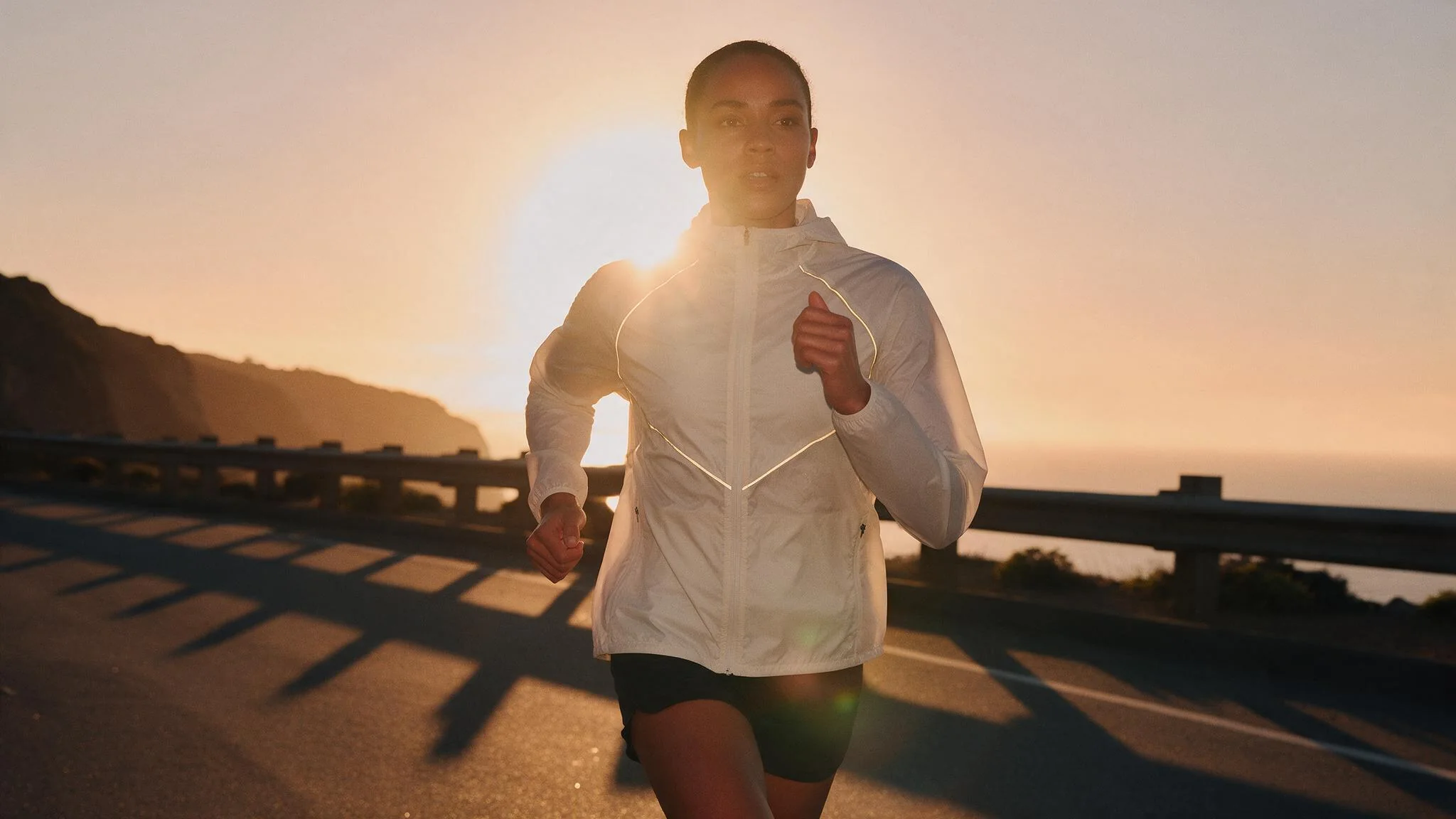 Runner in the Vesper shell at golden hour, a campaign still generated by Starwish